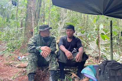 Manuel Ranoque, pai dos quatro filhos que desapareceram na selva, com um soldado do Exército colombiano.