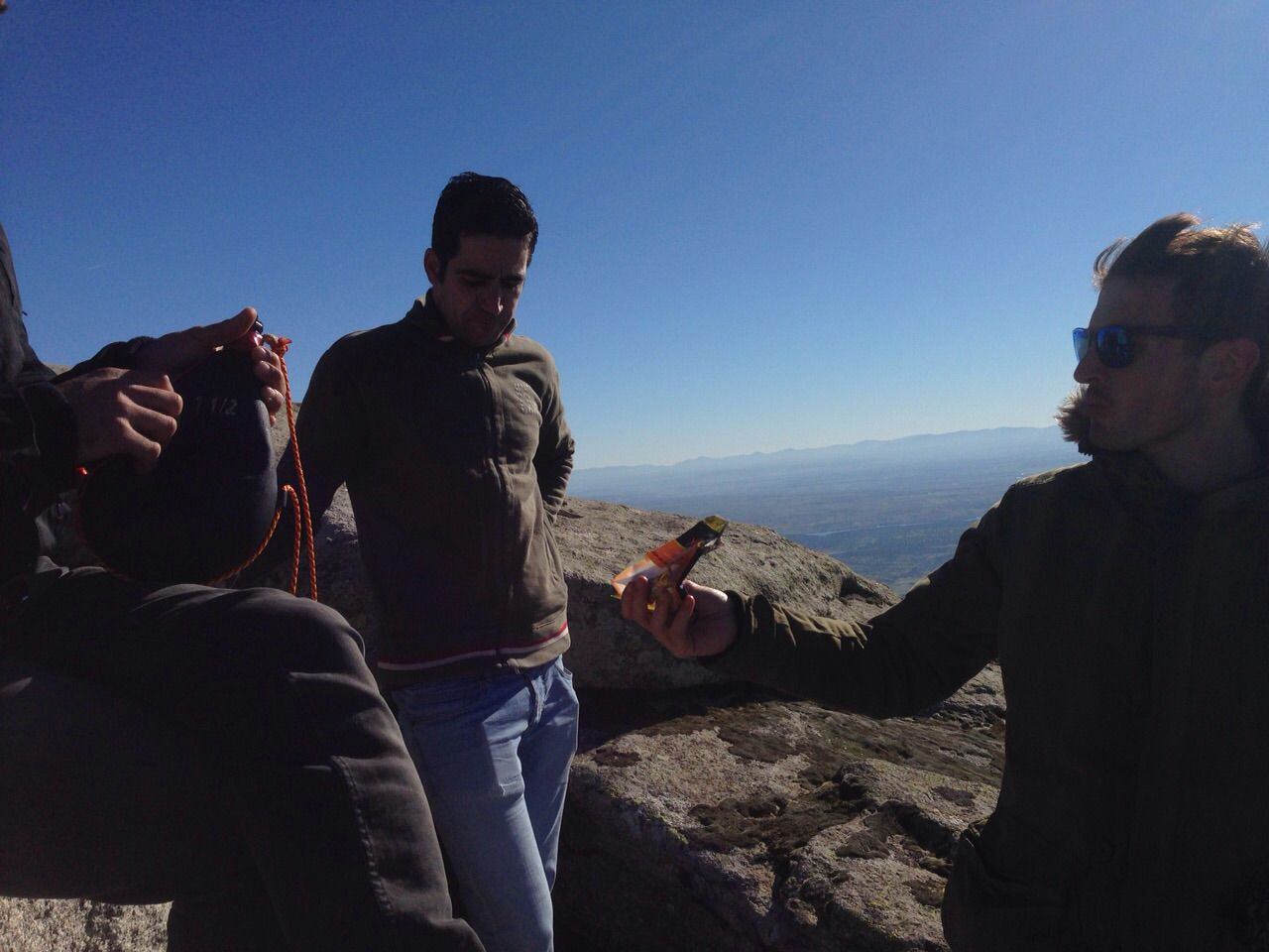 Miguel Corrales, a la derecha, ofrece unos frutos secos a sus amigos en el Piélago, en la sierra de San Vicente (Toledo).