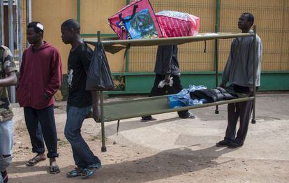 Residentes del Centro de Estancia Temporal de Inmigrantes (CETI) de Melilla trasladan unas literas, en una imagen de archivo de 2019.