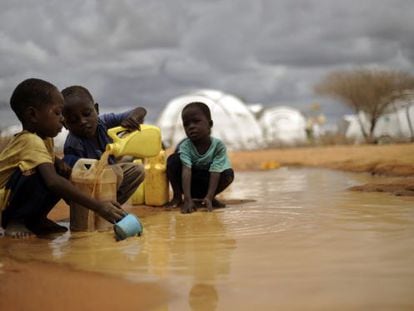Niños somalíes llenan garrafas con el agua de una charca en el campamento de refugiados de Dadaab, en Kenia.