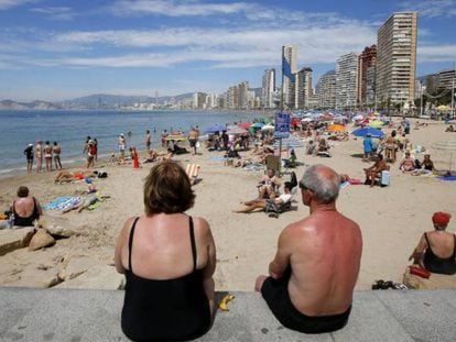 Una pareja de turistas observa la playa de Benidorm (Alicante).