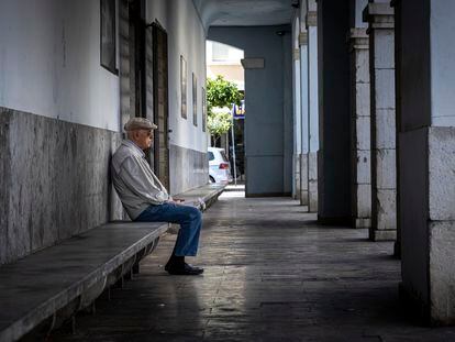 Una persona mayor descansa en un banco de una población valenciana.