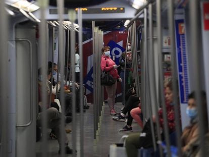Varios viajeros en el interior de un vagón del metro de Madrid.