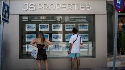Dos personas observan inmuebles en alquiler y en venta en un escaparate de una inmobiliaria ubicada en Palma de Mallorca.
(Foto de ARCHIVO)
28/6/2020