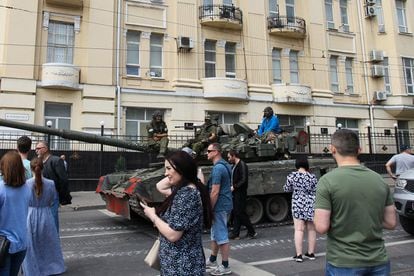 Civiles de la ciudad rusa de Rostov pasan delante de un tanque con miembros del grupo Wagner.