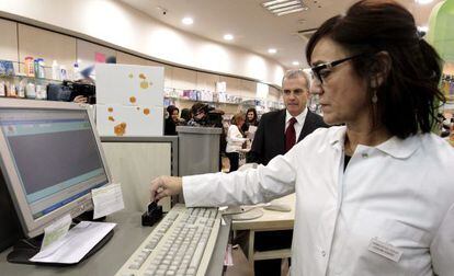 El director de Farmacia, I&ntilde;aki Betolaza, observa a una farmac&eacute;utica de Bilbao tramita una receta electr&oacute;nica.