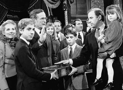 El senador Joe Biden (derecha) sostiene a su hija Ashley durante un ensayo de juramento en 1985 frente al entonces vicepresidente George Bush.