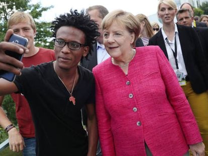 La canciller Merkel posa para una foto con un refugiado eritreo, este domingo en Belr&iacute;n.