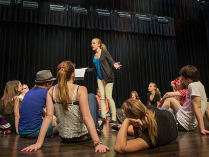 Estudiantes practican 'role playing' en un salón de actos.