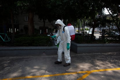 Un trabajador rocía un químico conocido como fenol para sanitizar la avenida Campos Elíseos