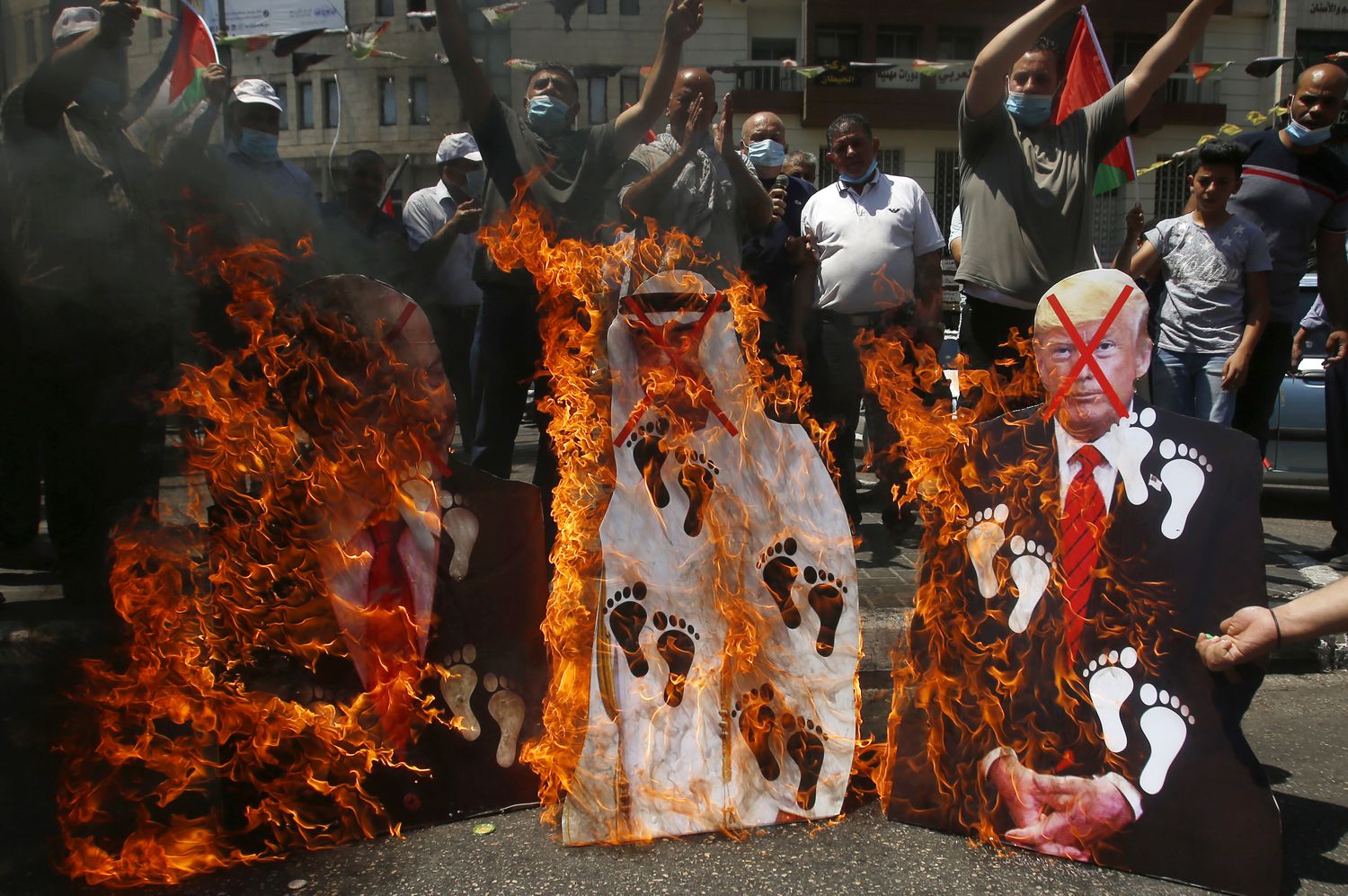 A group of Palestinians burn images of Benjamin Netanyahu, Prince Mohamed Bin Zayed and Donald Trump in Nablus, after the peace agreement between Israel and the United Arab Emirates.