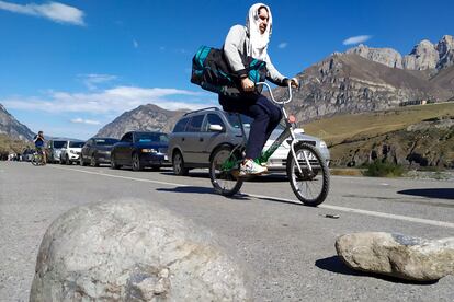 Un hombre cruza la frontera entre Rusia y Georgia en bicicleta, en el paso fronterizo de Verkhny Lars, el jueves.