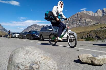 Un hombre cruza la frontera entre Rusia y Georgia en bicicleta, en el paso fronterizo de Verkhny Lars, el jueves. 