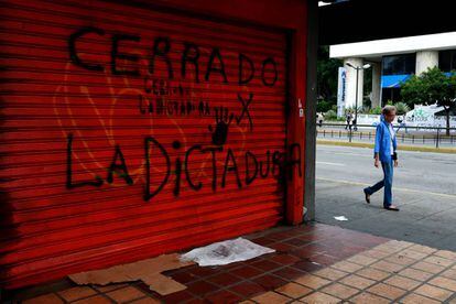 Una mujer pasa junto a un comercio cerrado por la huelga, ayer en Caracas.