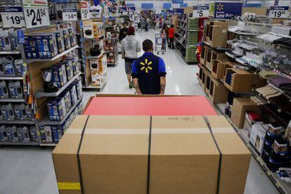 Un empleado arrastra mercancia en una tienda de Wal-Mart de Los &Aacute;ngeles (Estados Unidos)