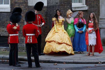 Mmiembros de la Guardia Galesa, un regimiento de la Guardia a pie de la División de Hogares, se reúnen con mujeres disfrazadas de personajes de las películas de Disney, en Downing Street, Londres (Inglaterra).