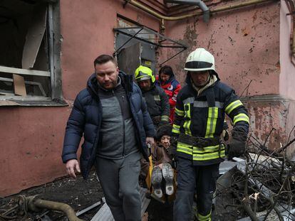Efectivos de los servicios de emergencia transportan a una mujer herida en un bombardeo en un edificio residencial en Járkov este domingo.