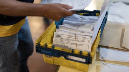 Un cartero entrega los votos por correo en una mesa electoral en Barcelona, este domingo.