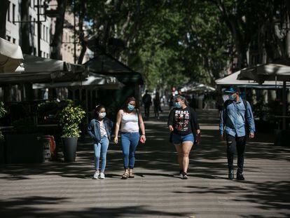 Una familia pasea por La Rambla de Barcelona.
