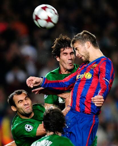 Gerard Piqué cabecea un balón ante la oposición de César Navas (en el centro) y Lasha Salukvadze (a la izquierda), ambos del Rubin Kazan, en un lance del partido de Liga de Campeones que enfrentó a ambos equipos en el Camp Nou, en 2009.