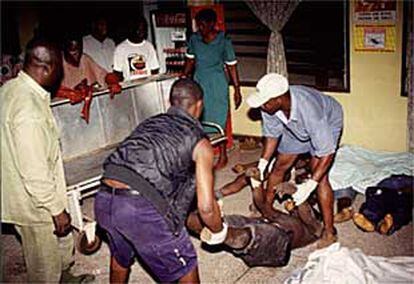 Empleados de un hospital colocan los cadáveres procedentes del estadio de fútbol de Accra, la capital de Ghana.