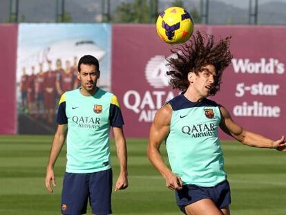 Busquets observa a Puyol en el entrenamiento del Barcelona. 