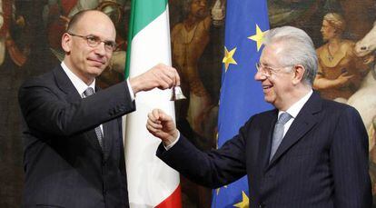 Enrico Letta (izq.), hace sonar una campanilla de plata en señal del inicio de su mandato, junto al jefe del goibierno saliente, Mario Monti.