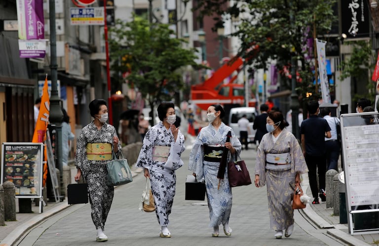 Unas mujeres pasean en Tokio con el traje tradicional de 'geisha', en julio.