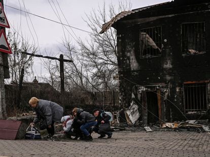 Un grupo de gente se protege de los bombardeos en la ciudad de Bucha, al oeste de Kiev