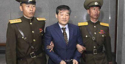 Dos agentes norcoreanos llevan detenido a Kim Dong Chul, este 29 de abril.