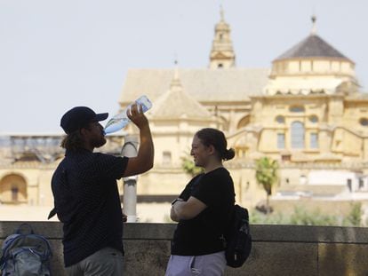 Dos turistas descansan y beben agua frente a la Mezquita de Córdoba, el pasado 19 de mayo.