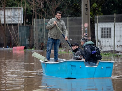 Personas se trasladan en botes por calles inundadas tras el desborde del río Claro, en la ciudad de Talca, Chile.