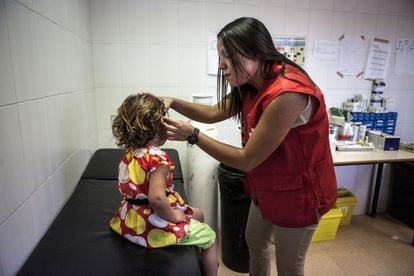 La enfermera Hana Marzok desinfecta el oído de una niña siria aquejada de otitis en la enfermería del CETI.