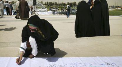 Una mujer firma en un acto en Teher&aacute;n en apoyo de un acuerdo en las negociaciones nucleares. 