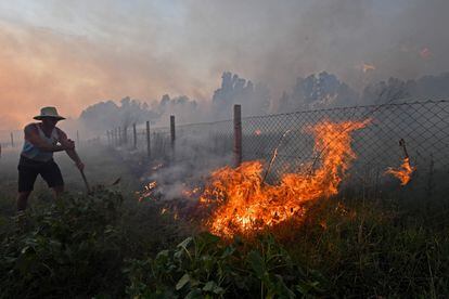 Un residente intenta apagar las llamas en Tabarka, este lunes.  
