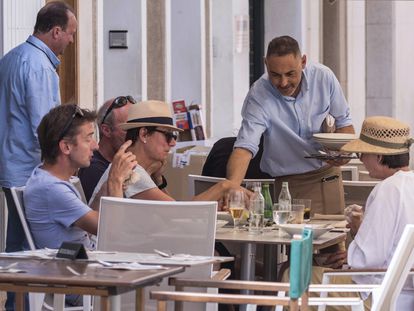 Un camarero servía a unos clientes, el jueves en una terraza en Maó (Menorca).