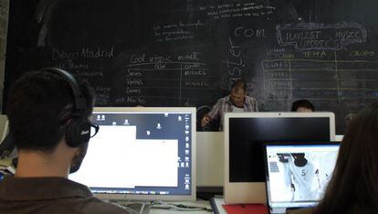 Estudiantes en un aula de 'coworking' con sus ordenadores.