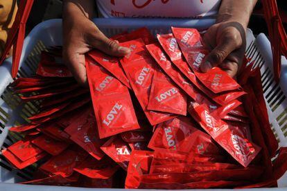 Personas cogen preservativos en Nueva Delhi (India), durante el D&iacute;a Internacional del Cond&oacute;n.
 