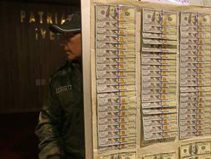 Un policía boliviano muestra parte de los 7.240 dólares recuperados en una vivienda, luego de que el Banco Central de Bolivia (BCB) sufriera dos robos por 210.000 dólares, de los que son sospechosos tres empleados y dos personas ajenas a la entidad.