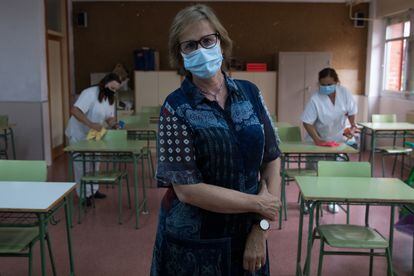Mariam González, directora del IES Juan de Mairena, en San Sebastián de los Reyes, posa en un aula mientras el personal de limpieza realiza labores de higienización.