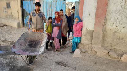 Shikeb, con la carretilla, y detrás (de izquierda a derecha) Zahra, Lida, Anahita, Fátima, Tamim y una vecina, a la puerta de la casa donde han alquilado una habitación en Kabul