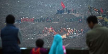 Un grupo de personas observa este lunes las labores de rescate tras el derrumbe de 33 edificios en Shenzhen, China.