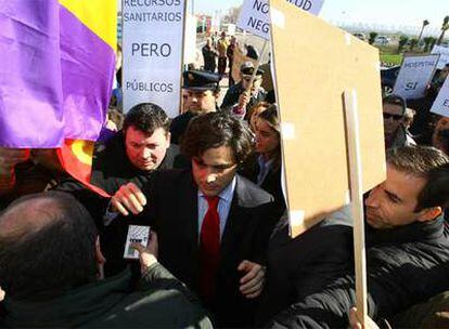 Varios manifestantes rodean a Juan José Güemes a las puertas del hospital de Parla.