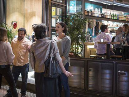 Un grupo de jóvenes fuma a las puertas de un local en la calle de Ponzano, en Madrid.