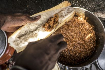 En África Central y Occidental los reyes de la producción de legumbres son los caupíes, también conocidos como chícharos salvajes, judías de careta o carillas, entre otros nombres. En varios países es común una papilla o puré de legumbres (alubias o guisantes) acompañada de salsas y carnes. En Chad, por ejemplo, se consuen muchas alubias pintas y en Senegal se desayuna a menudo el ndambé, un bocadillo de judías guisadas y tomate muy especiado. En la imagen, un hombre prepara un bocadillo de frijoles en un puesto en el mercado de la capital de este último país.