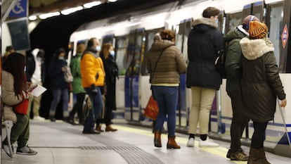 Varias personas esperan para subirse al vagón en una estación del Metro de Madrid.