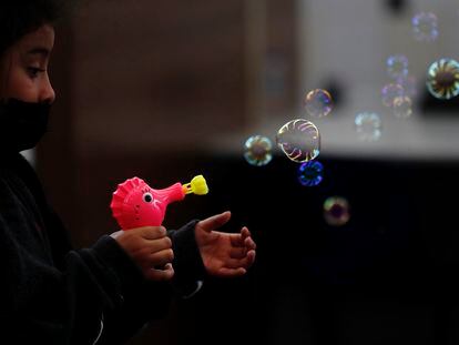 Una niña juega con una pistola de burbujas regalada por el personal de Migración luego de ser deportada con su familia desde Texas a Ciudad de Guatemala (Guatemala).