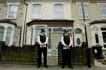 Dos policías montan guardia frente a una vivienda registrada en Londres.