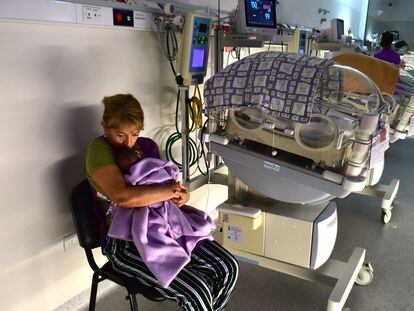 Irma Castro abraza a un bebe junto a una incubadora, en la sala de cuidados intermedios de la Maternidad provincial de Córdoba (Argentina), el 14 de enero de 2024.