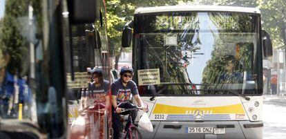 Un ciclista se abre paso entre dos autobuses.